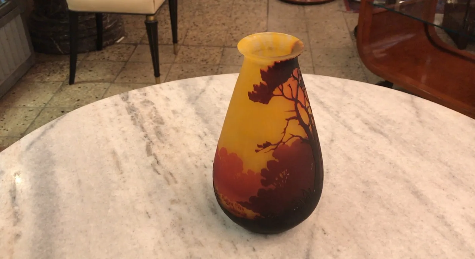 Decorative antique bottle with warm hues and silhouettes of trees.
