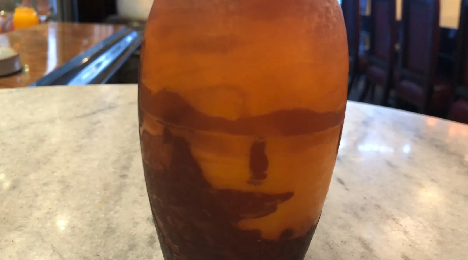 Vidrio antiguo firmado de Muller Fres con decoración única visible en un entorno de restaurante elegante.