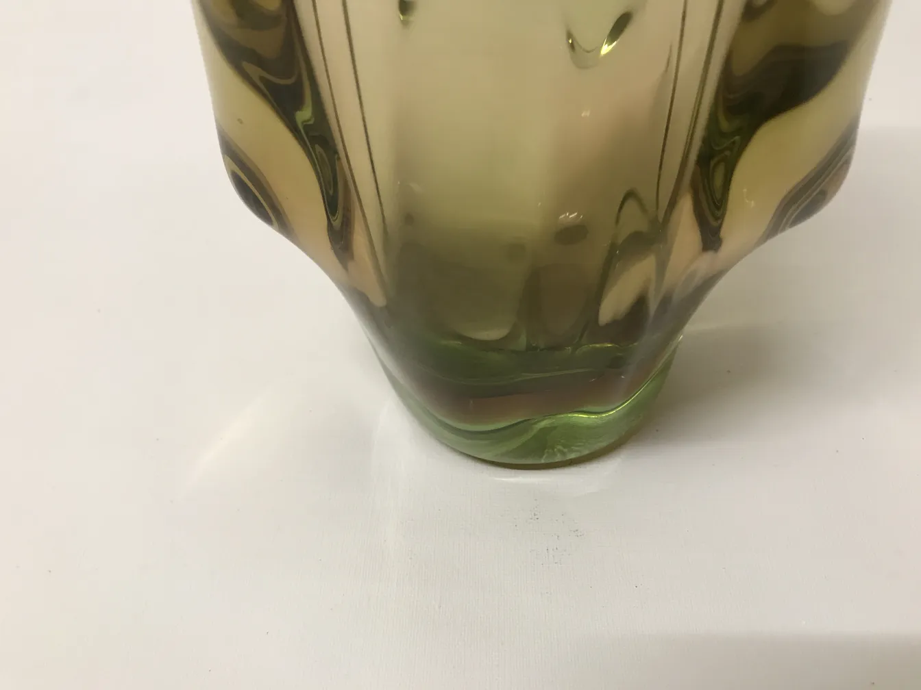 Vaso di murano antico con forme fluide e finitura colorata, posato su sfondo bianco.