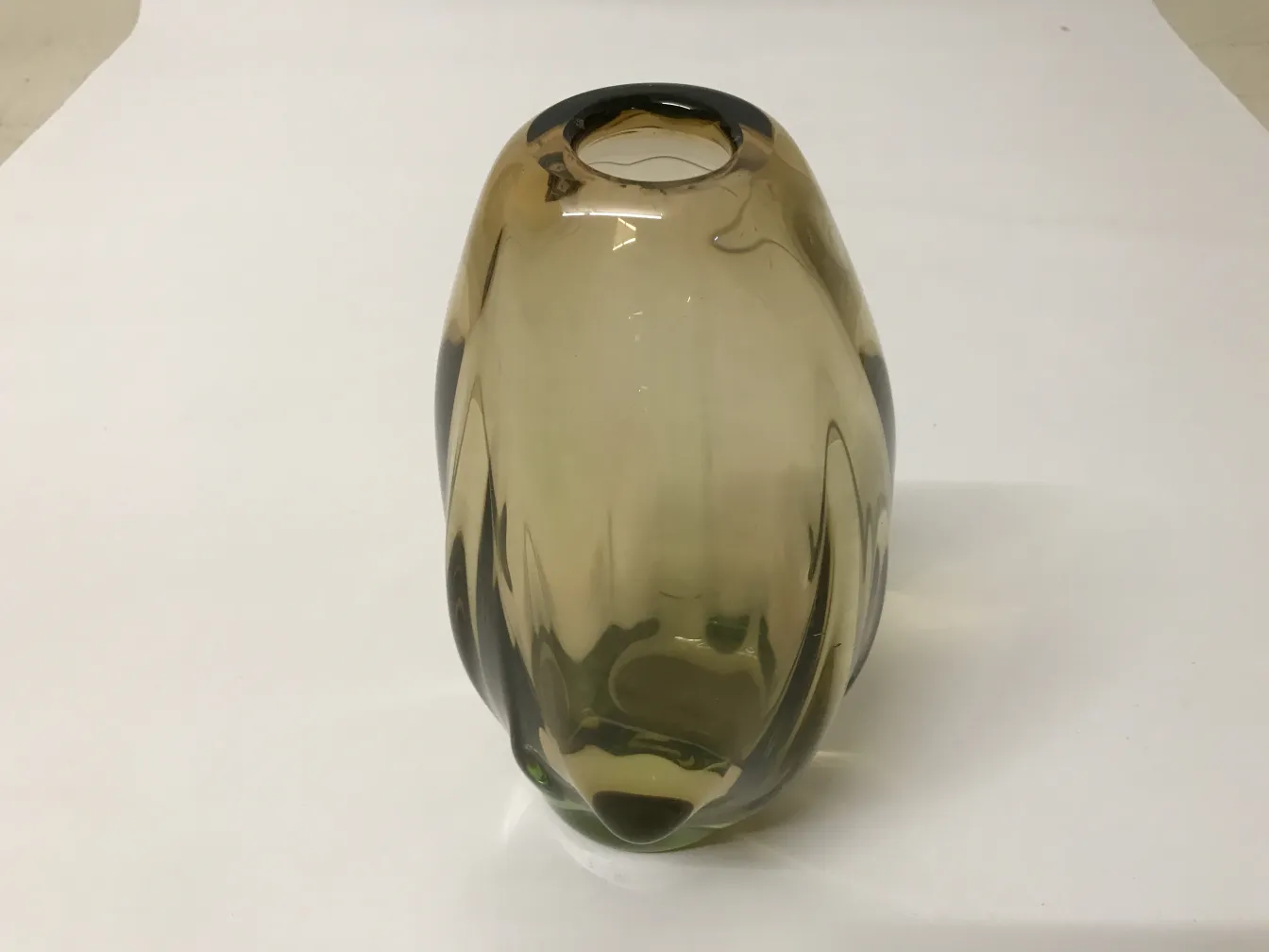 Antique Murano vase in amber color, resembling a bottle shape. White background.
