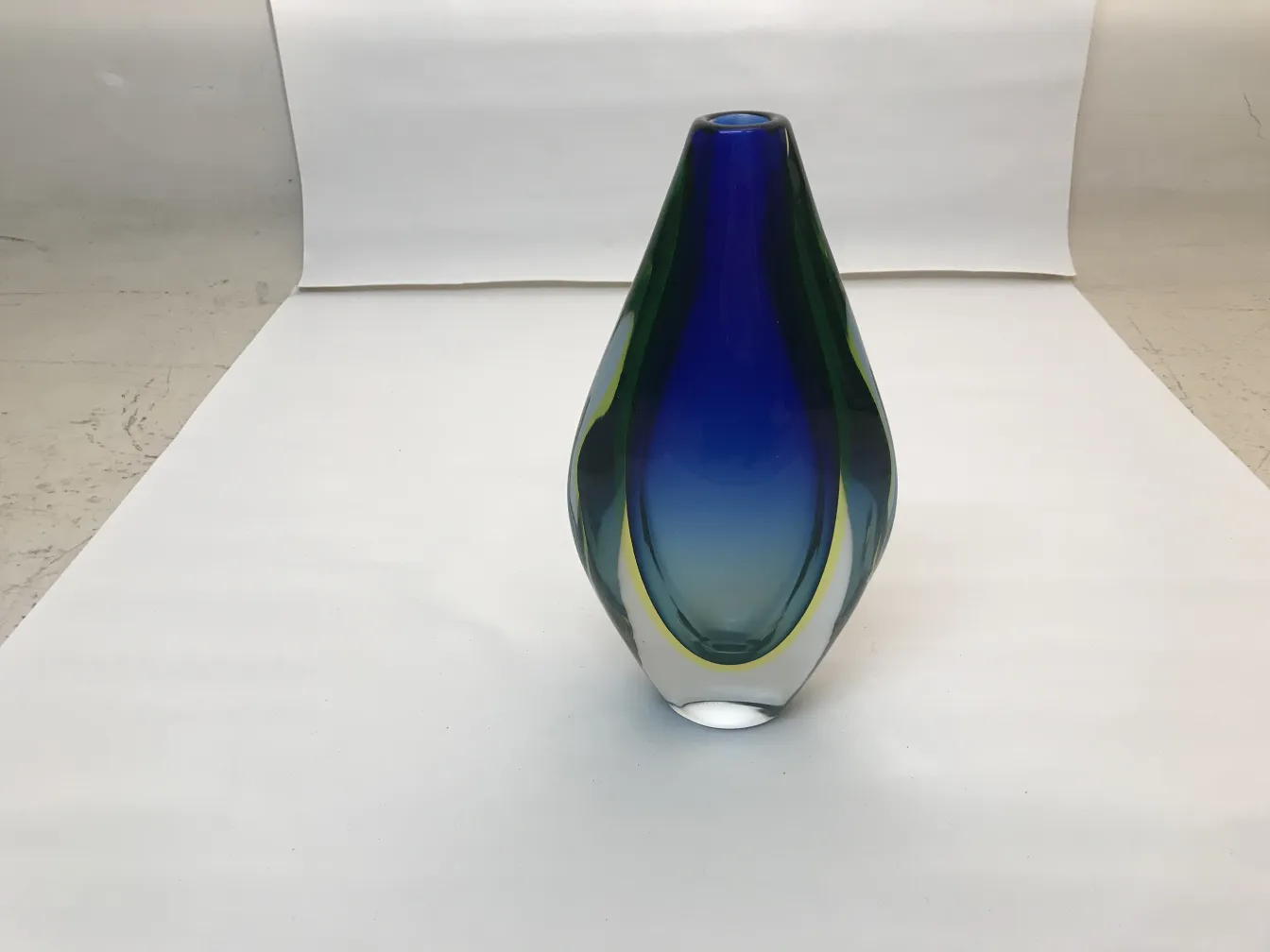 Vase Murano sculpté en formes élégantes et couleurs vibrantes sur fond blanc.