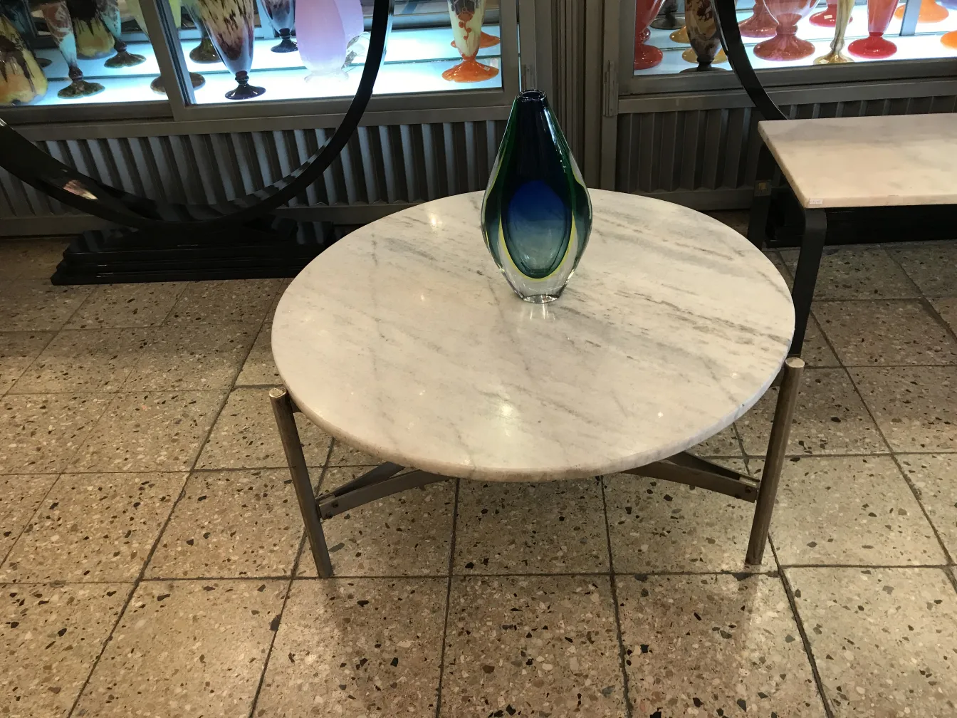 murano-vase auf marmor-tisch, blaue und grüne farbe, mit anderen vasen im hintergrund