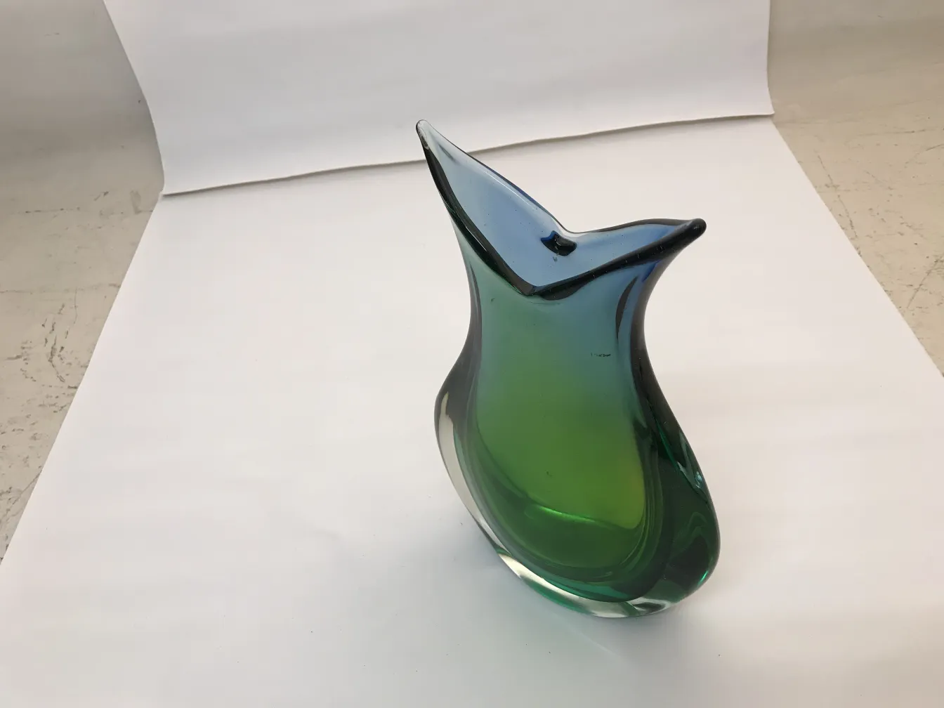 antike murano-vase, grüne und blaue farben, elegante kurvenform, neutraler hintergrund