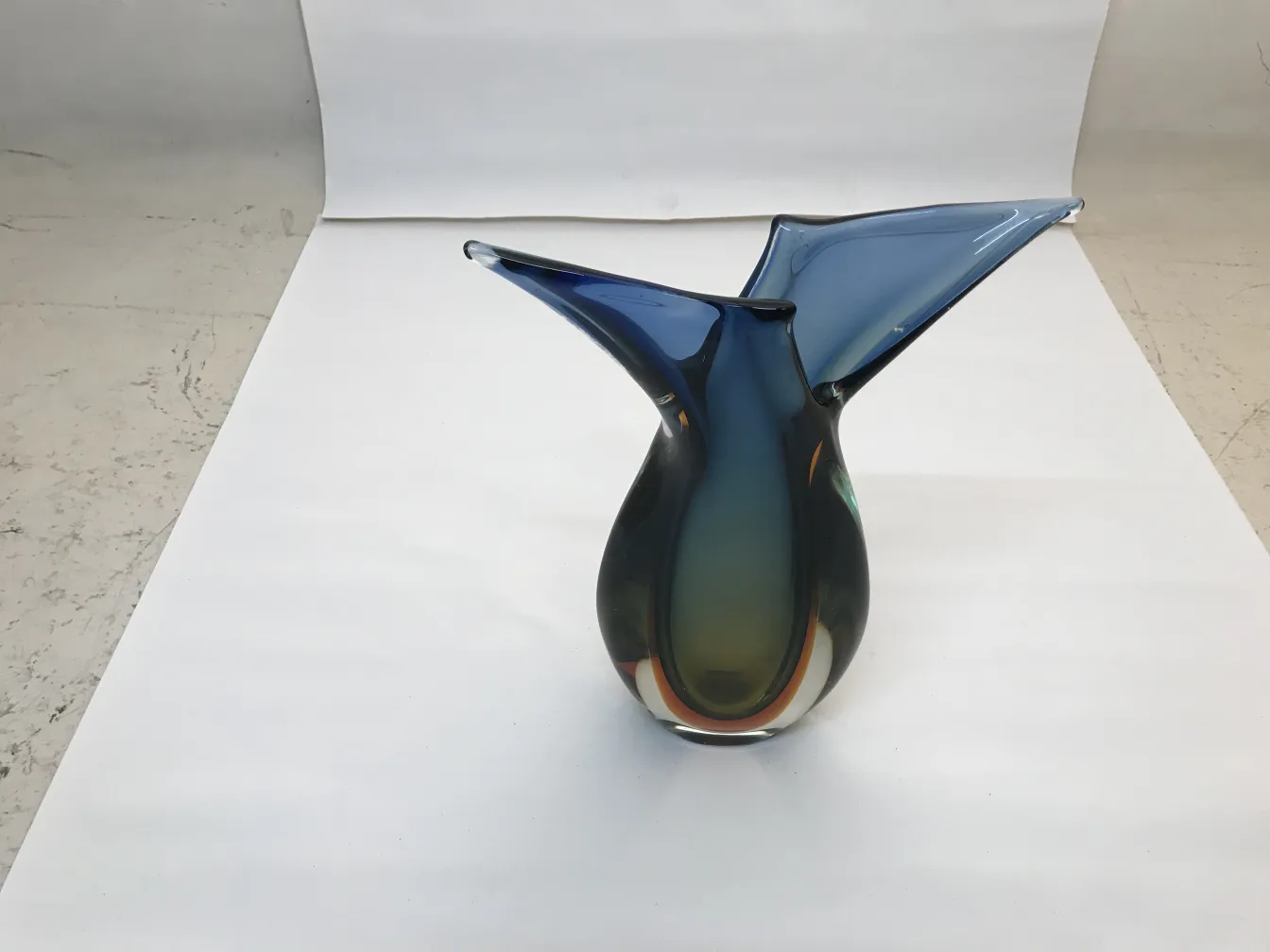 vaso di murano con forma elegante in tonalità di blu e verde, su uno sfondo neutro