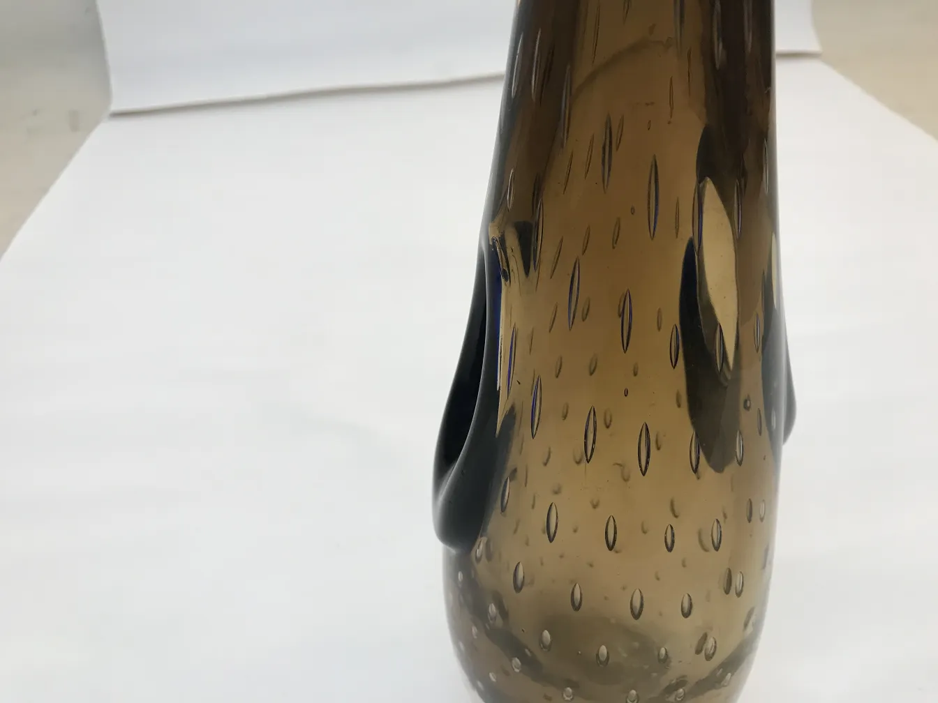 vaso antigo de Murano com forma elegante, tons marrons e detalhes únicos, ambiente clássico.