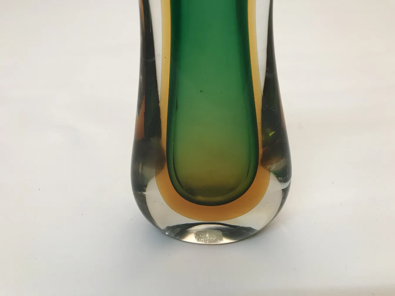 Murano vase with green and yellow hues, antique, in a simple setting.