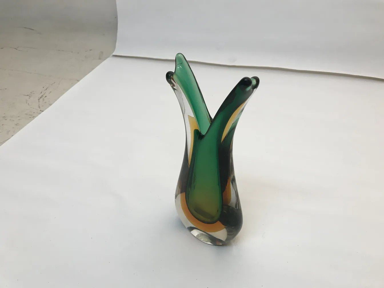 antik murano-vase mit fließendem grünem und gelbem design, neutraler hintergrund