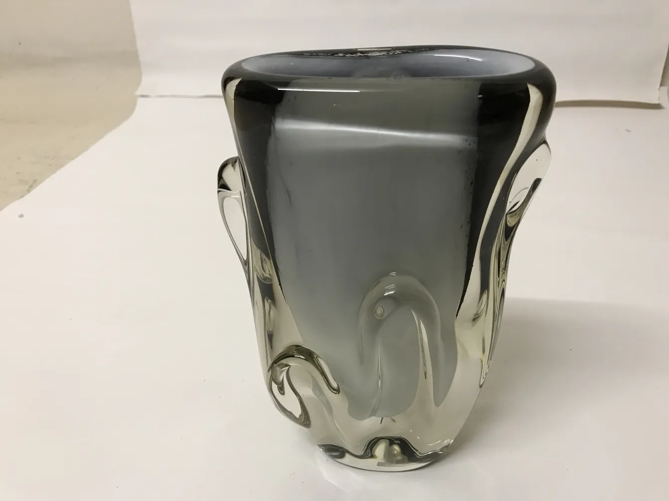 vaso di murano con forme eleganti e tonalità scure in un ambiente neutro