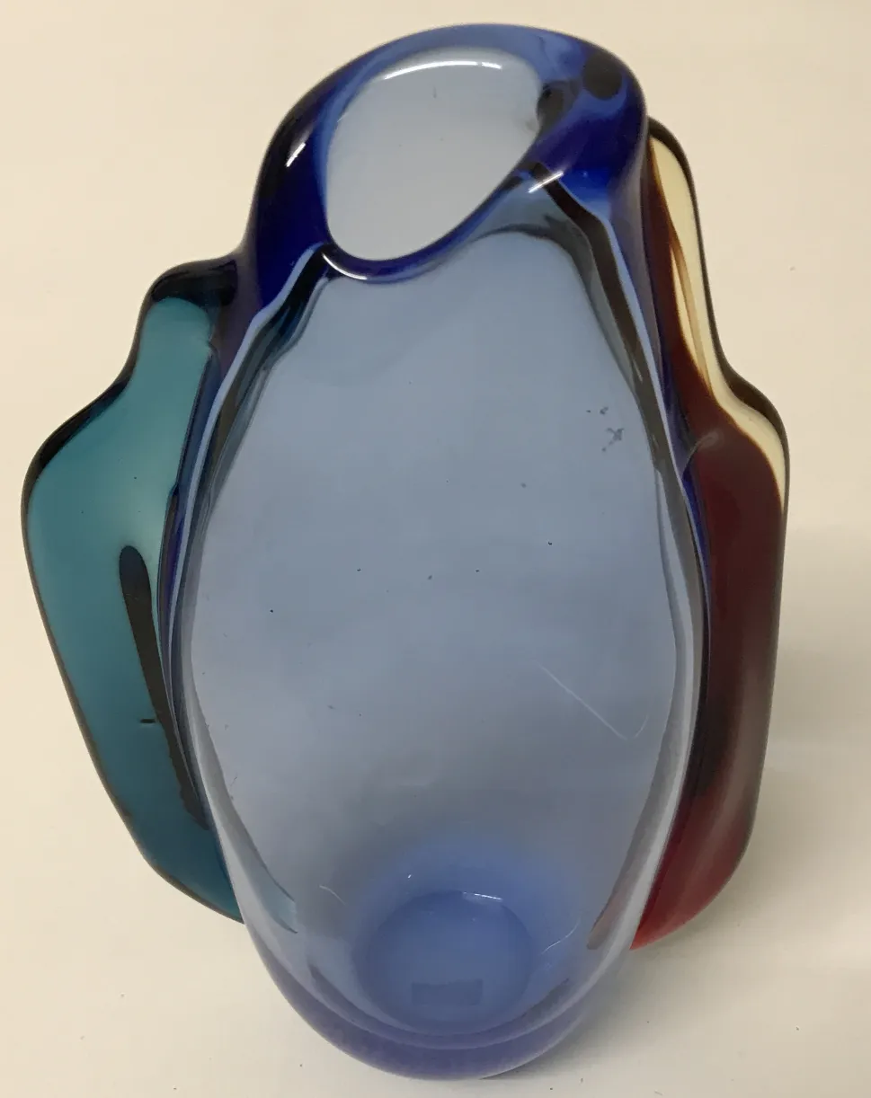 vase murano ancien avec des couleurs vives et des courbes douces dans un cadre neutre