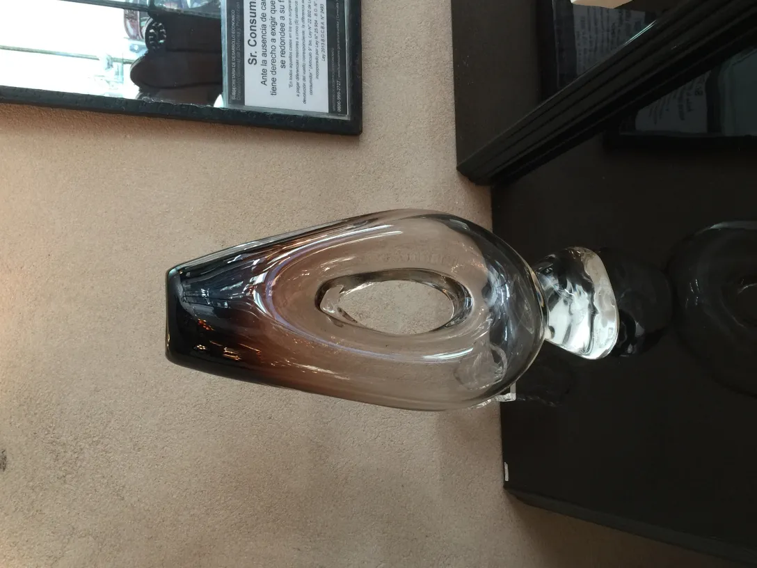 Florero de Murano antigüedad con forma ovalada y colores oscuros, en un ambiente elegante.