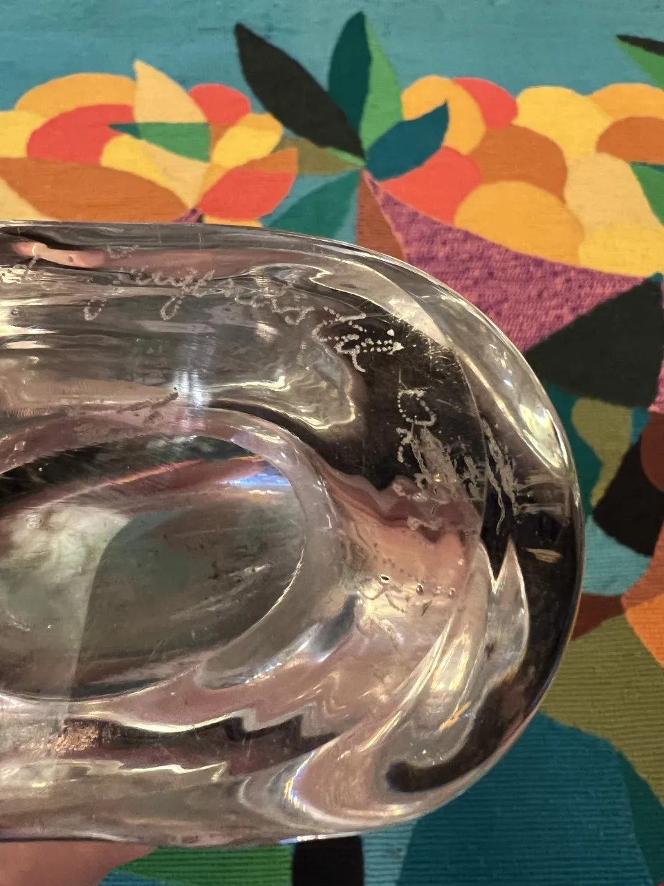 klare Murano-Vase mit eleganten Designs vor farbenfrohem Hintergrund