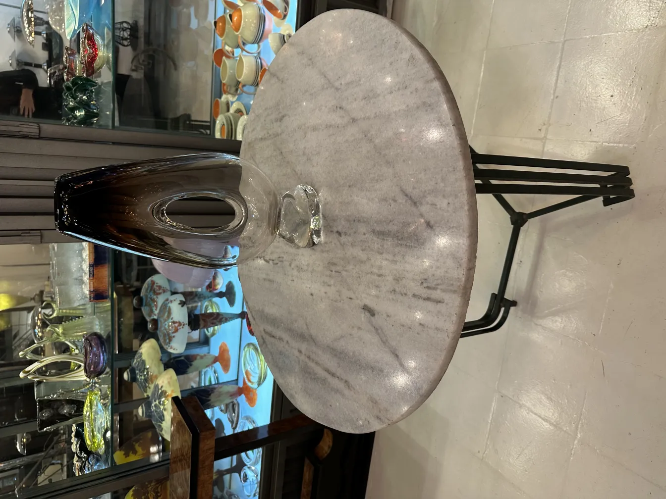 Vaso di Murano antico con forma elegante e tono scuro, esposto in un ambiente di antiquariato.