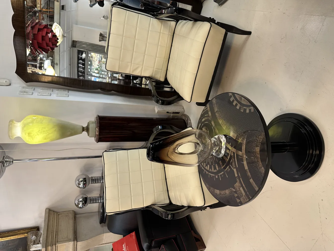 vaso de murano antigo com forma curva e brilho, em um ambiente decorado com cadeiras elegantes