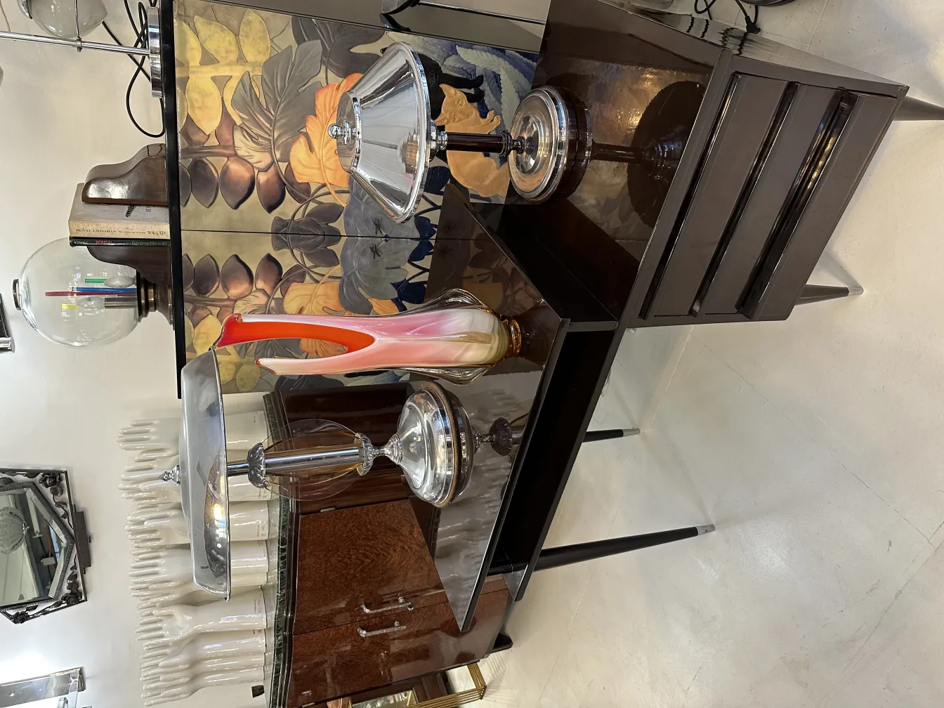 Un elegante florero de Murano antiguo en una mesa elegante con otros objetos decorativos.