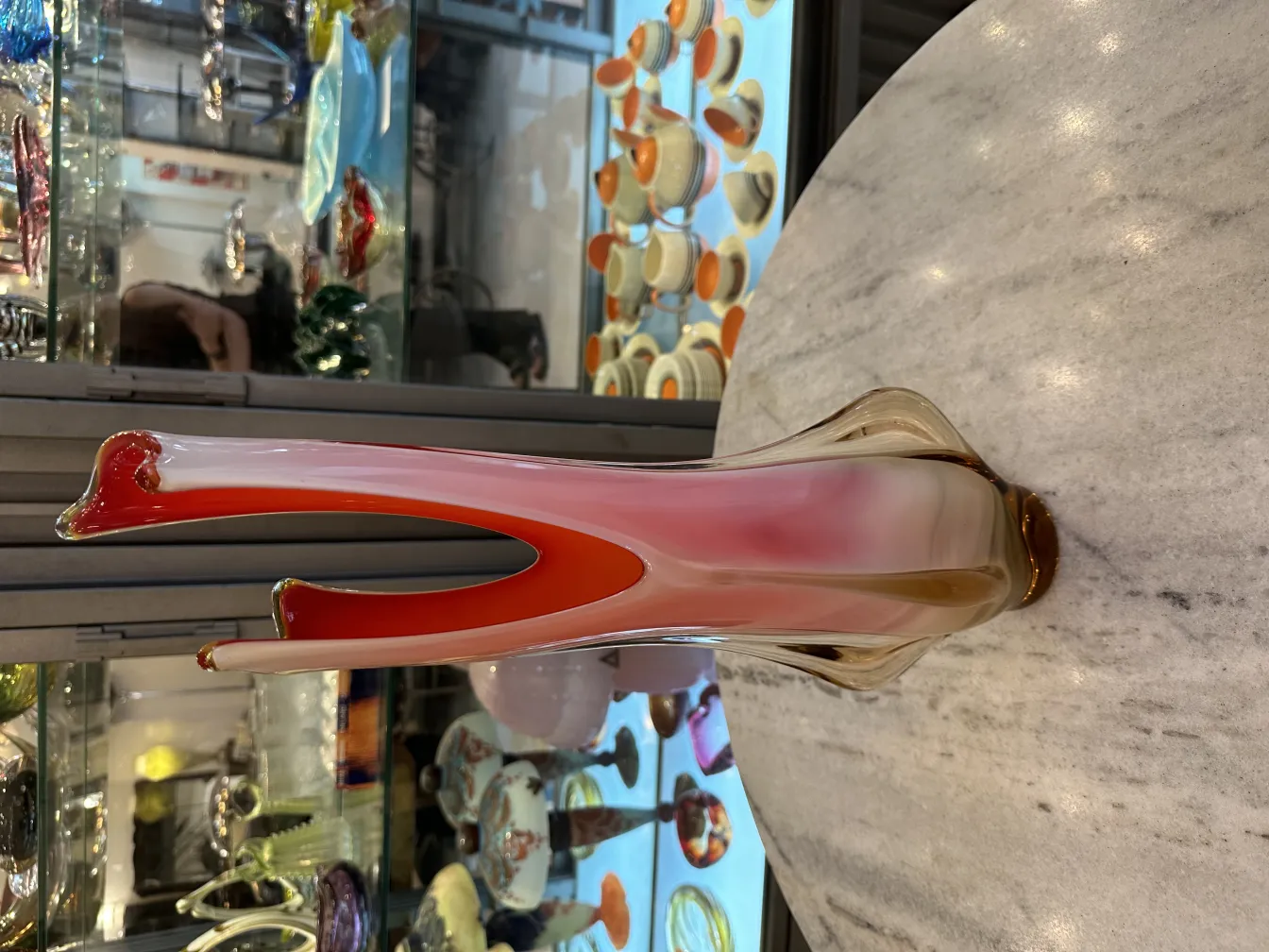 antique murano vase with colorful curved design on a marble table