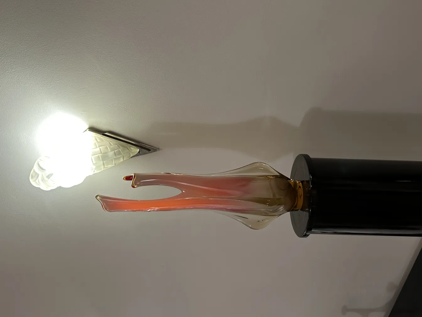 Florero de Murano antiguo con forma elegante y color suave, en un entorno decorativo.