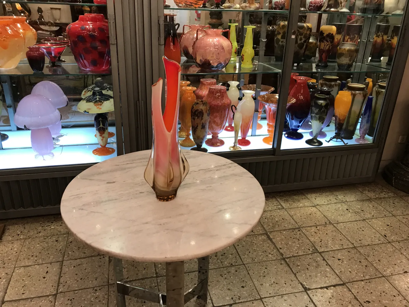 florero antiguo de murano en una mesa redonda con otros floreros de fondo