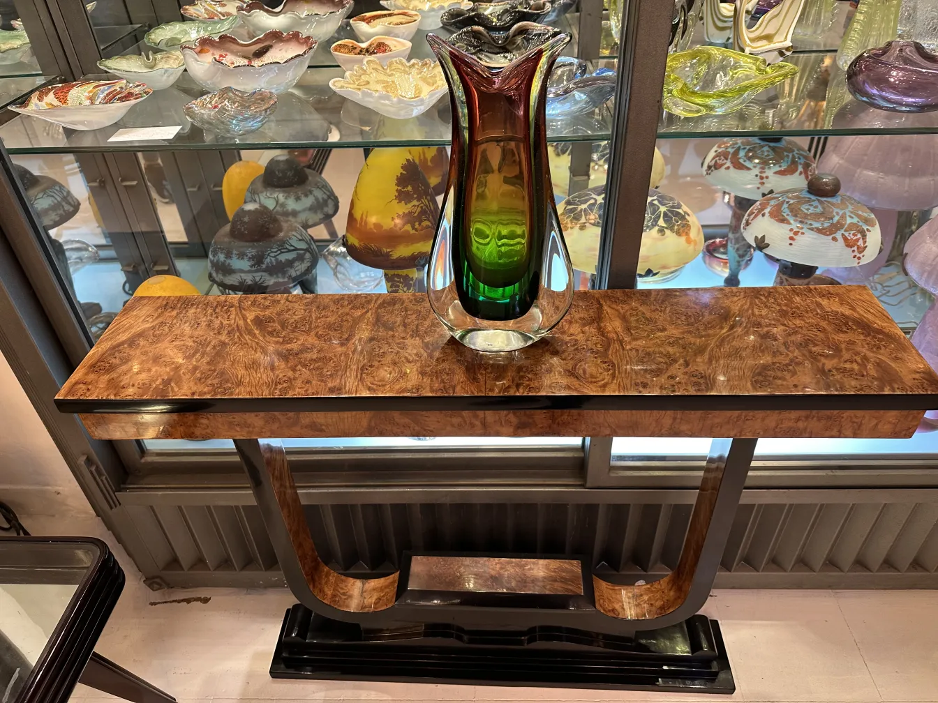 多彩的古董穆拉诺花瓶放在优雅的桌子上，背景有装饰品。