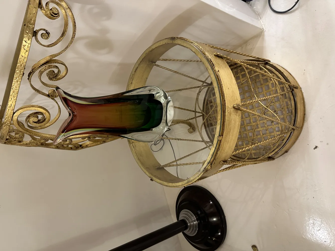 vase di murano antico con forma stilizzata e colori bianco, verde e ambra, su un tavolo dorato