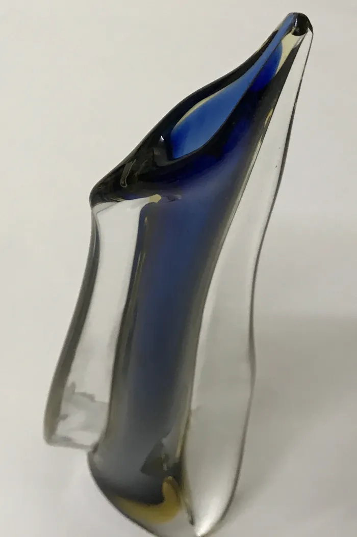 murano-glas mit gewellter Form und blauen Farben auf einem weißen Hintergrund.