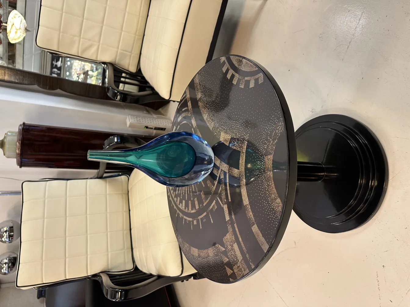 florero de murano en la mesa con sillas blancas