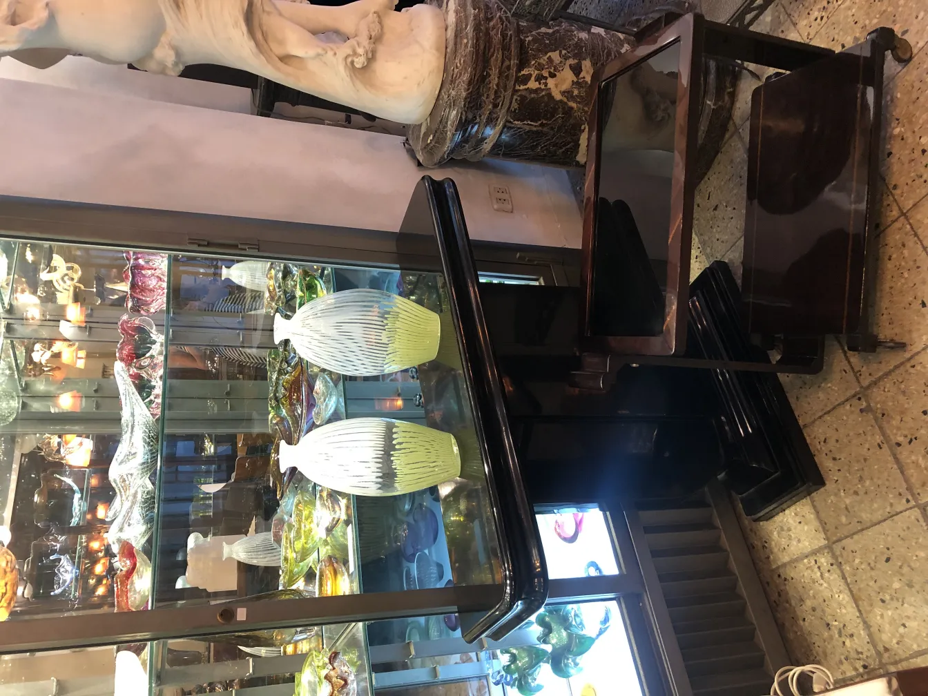 vetro di murano antico con motivo a righe chiare e scure, esposto in un ambiente elegante.