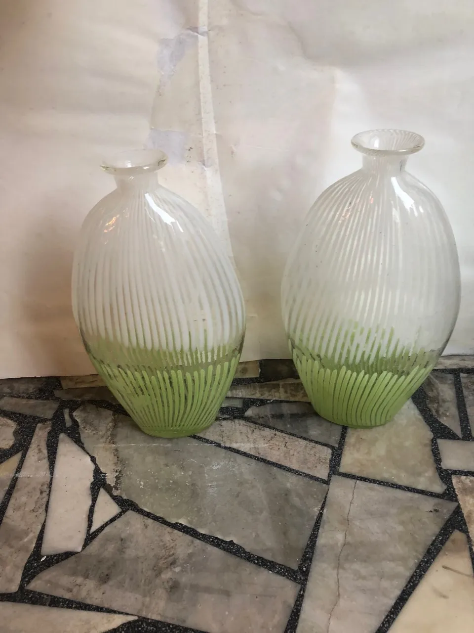 vase antico di murano con design rigato e base verde, su pietra di marmo.