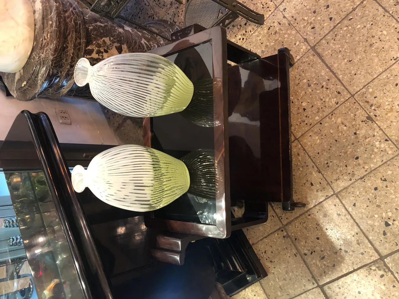 vaso de murano antigo com linhas decorativas em tons claros, em uma mesa elegante