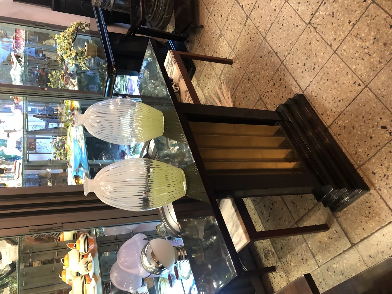 Antikes Murano-Glas mit dekorativem Design, eleganten Formen und sanften Farben, kombiniert mit einem klassischen Tisch.