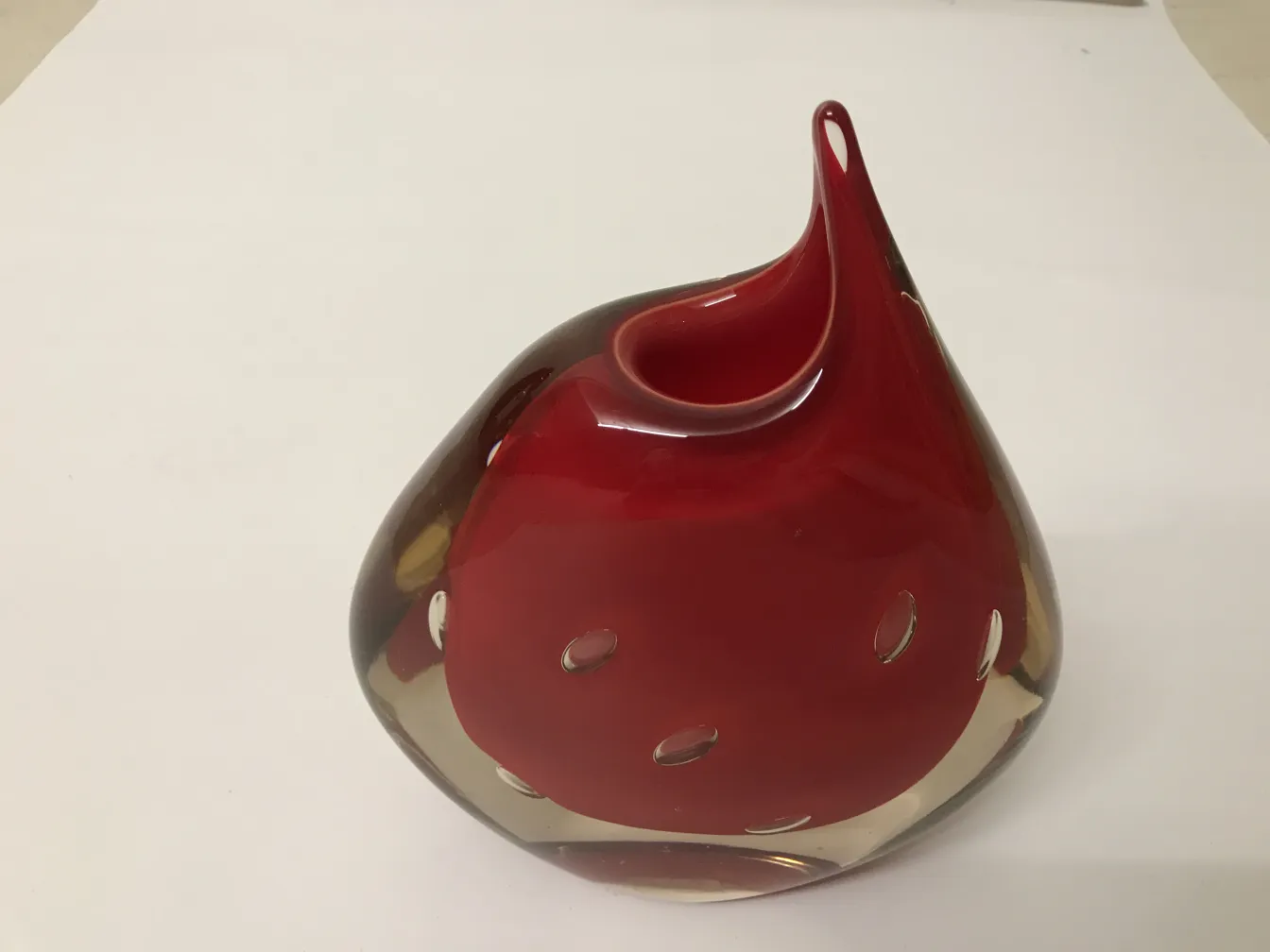 antique murano vase with creative design in red tones, set in a neutral environment