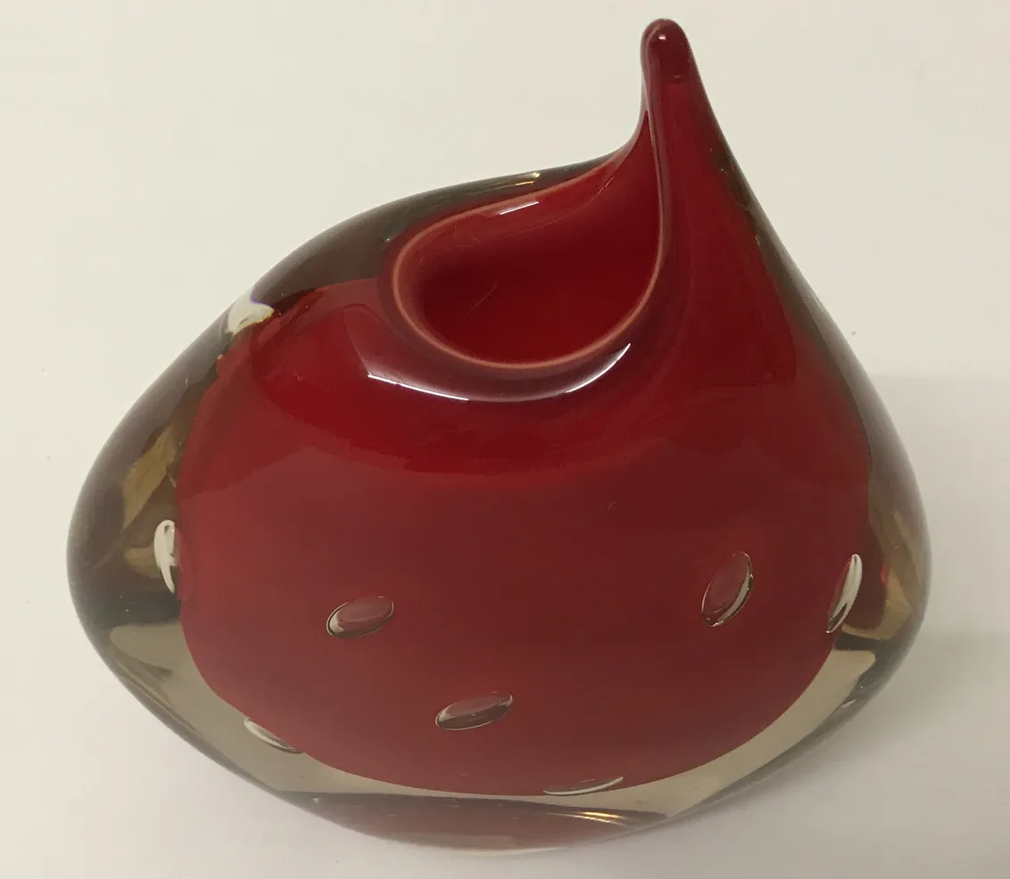 vaso de murano vermelho com forma ondulada e buracos decorativos