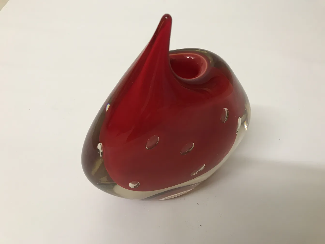 Vaso de Murano vermelho com forma distinta e detalhes ao redor.