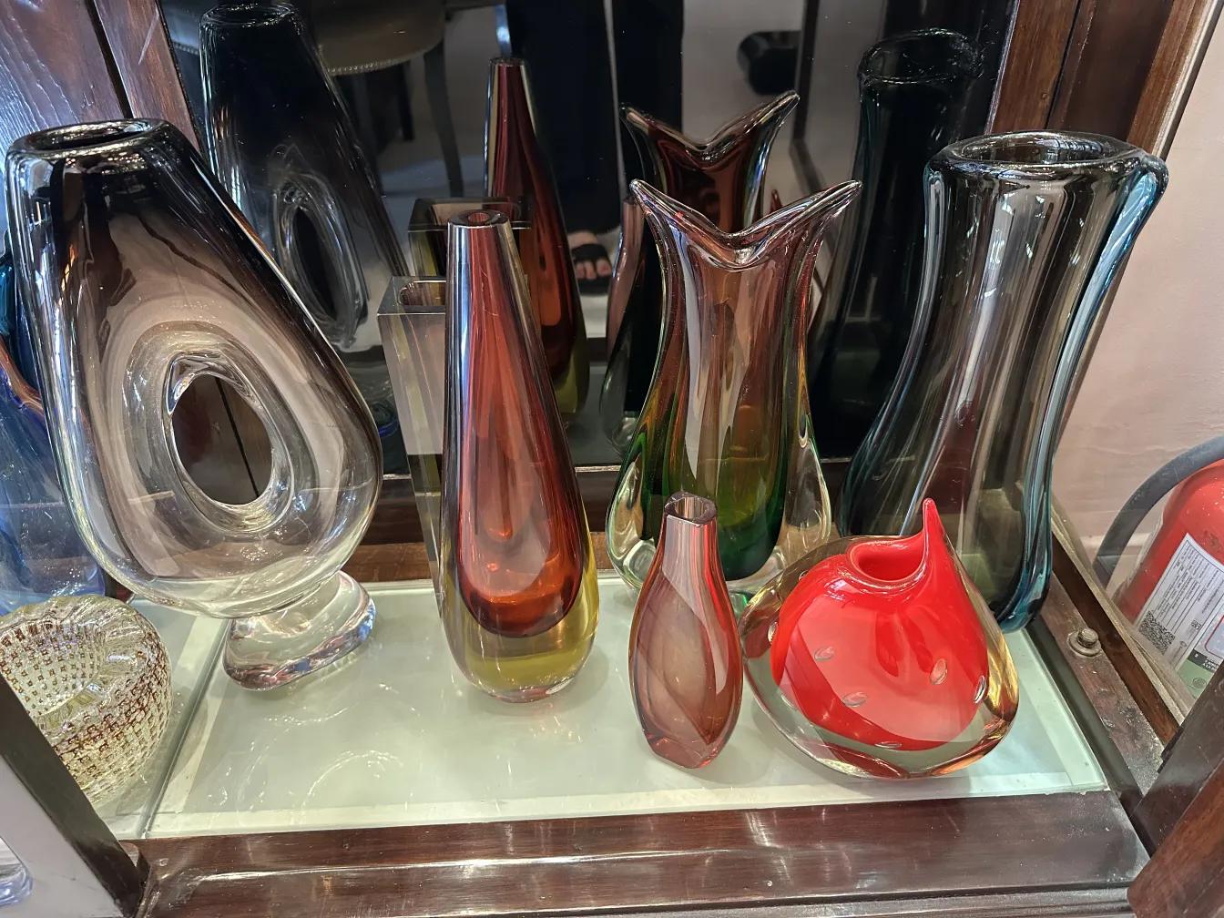 vaso antigo de Murano em várias formas e cores vibrantes, ao lado de outros vasos