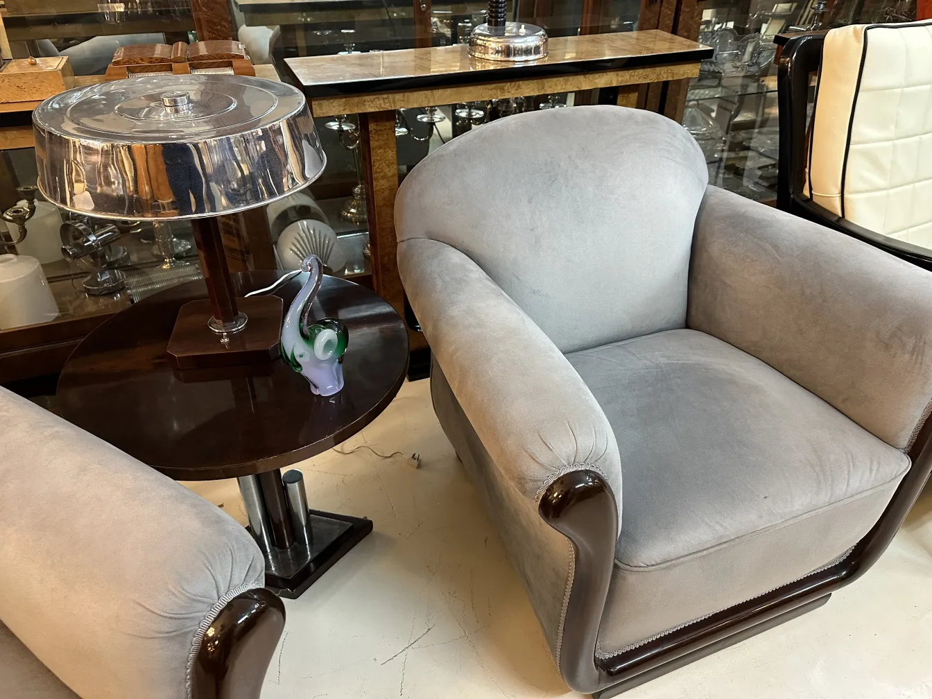 色彩丰富的穆拉诺雕塑放在桌子上，上面有灯和扶手椅