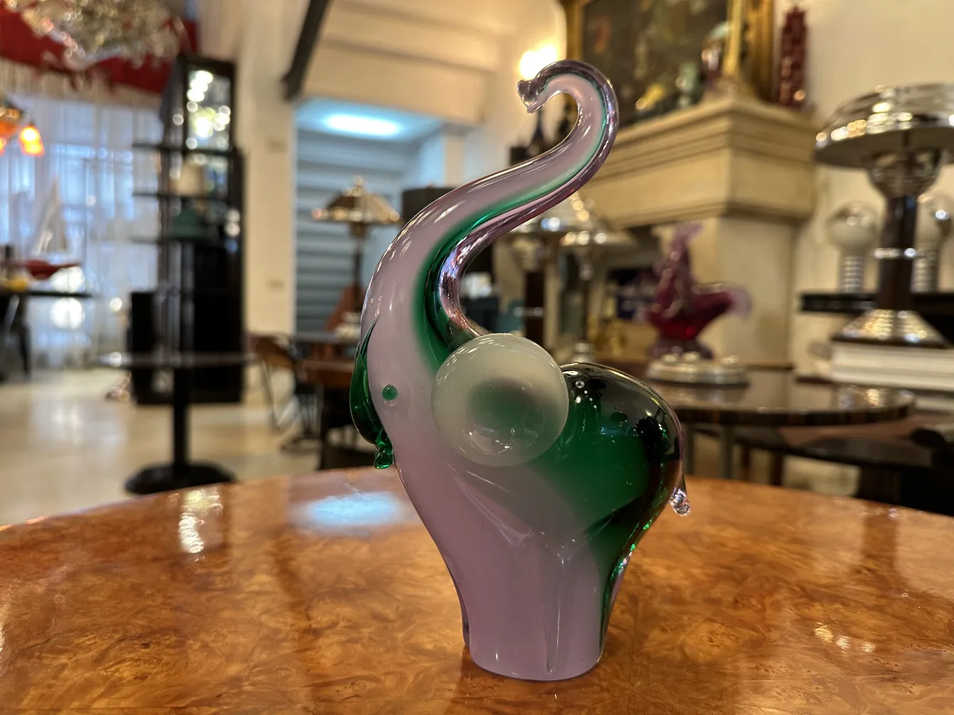 Scultura murano a forma di elefante con colori vivaci in un ambiente decorativo.