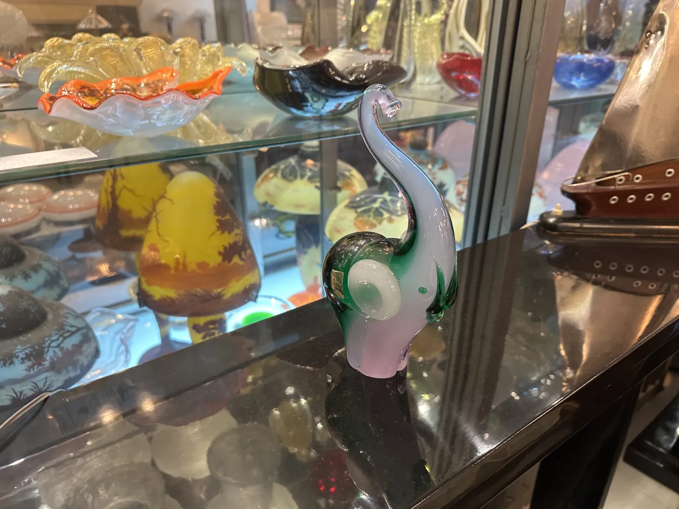 escultura de murano antiga com forma elegante e cores vibrantes em um ambiente de antiguidades