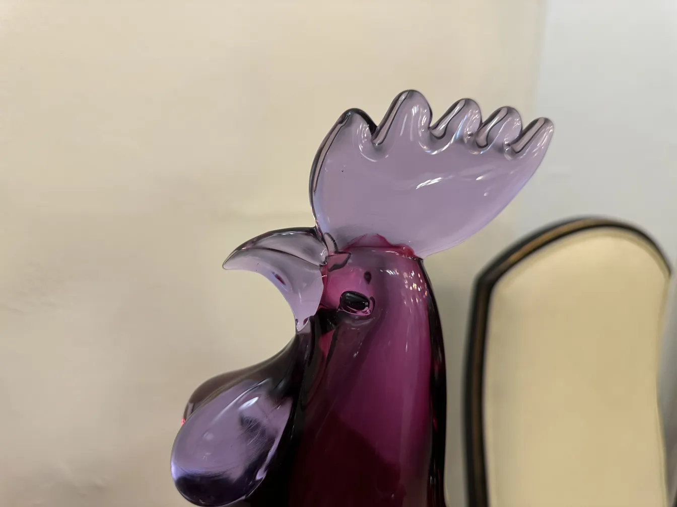 Antike Murano-Skulptur in Form eines bunten Hahns vor hellem Hintergrund.