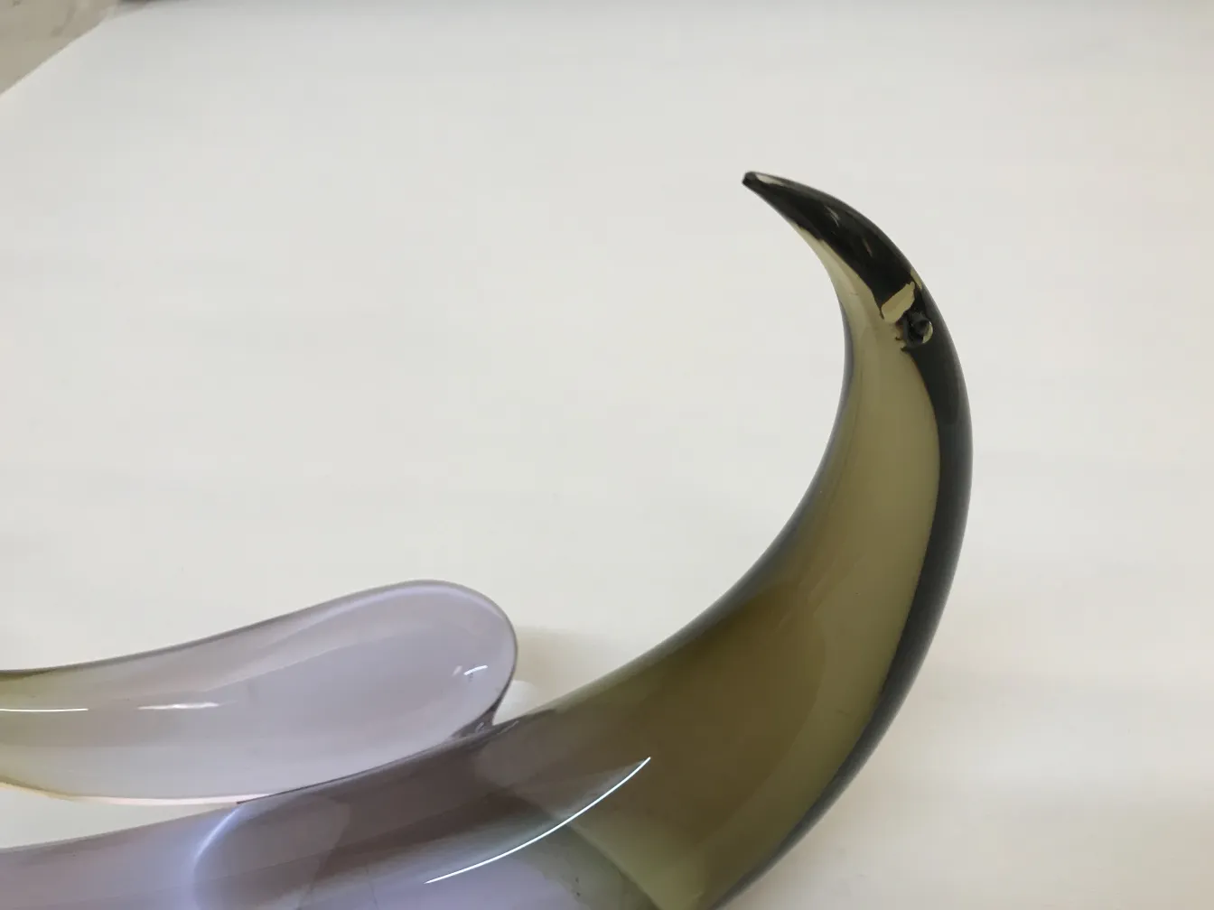 Escultura de Murano antiga com formas fluidas e cores variadas em um fundo claro.