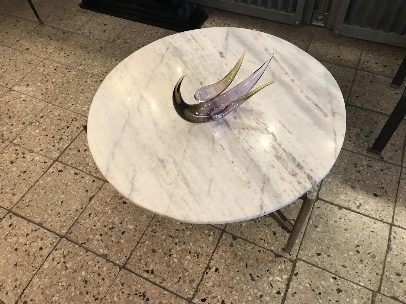 sculpture antique de murano avec des formes élégantes et des couleurs douces sur une table blanche