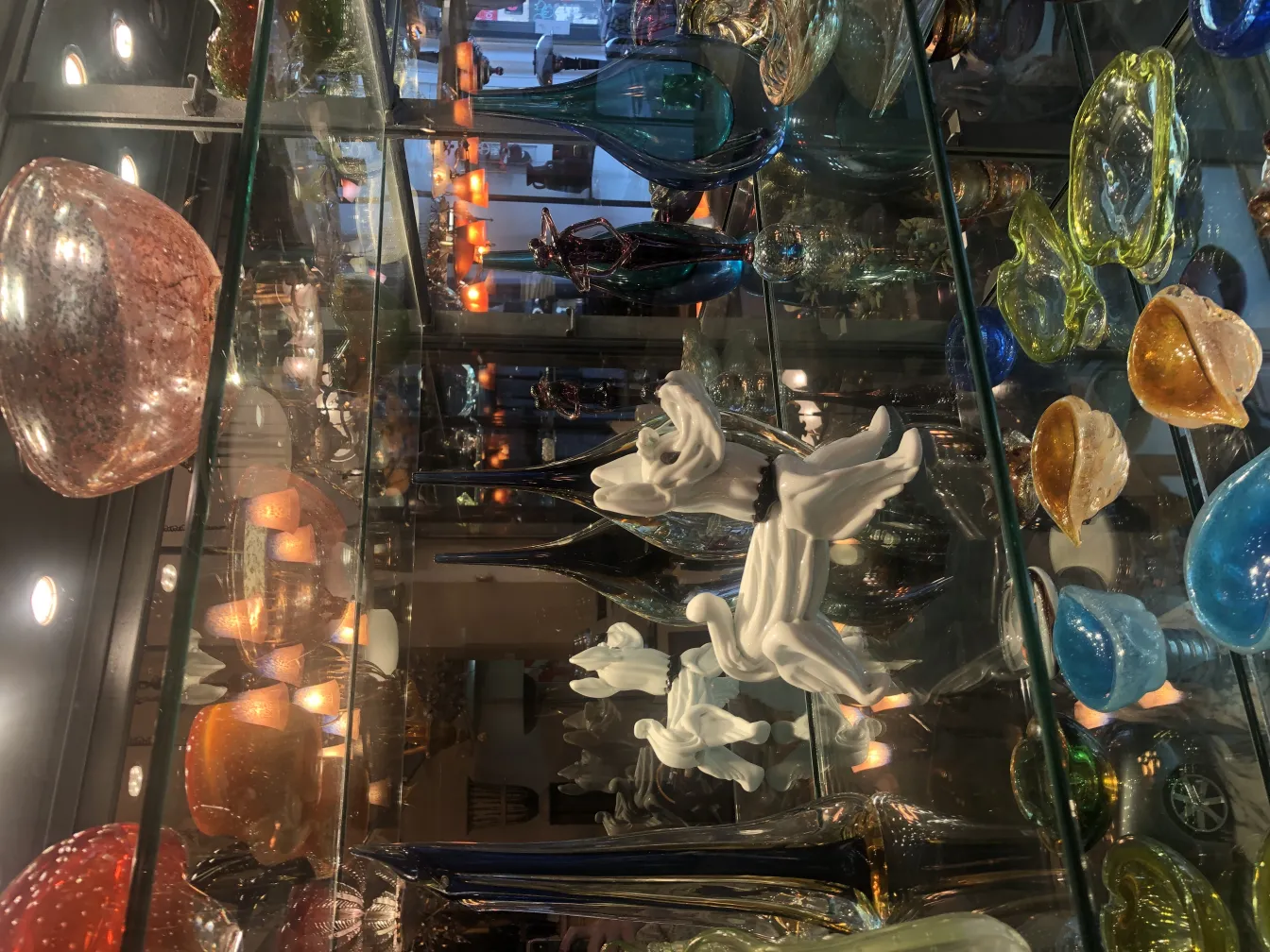 antique murano sculpture with elegant shapes and colorful decorations, surrounded by decorative objects