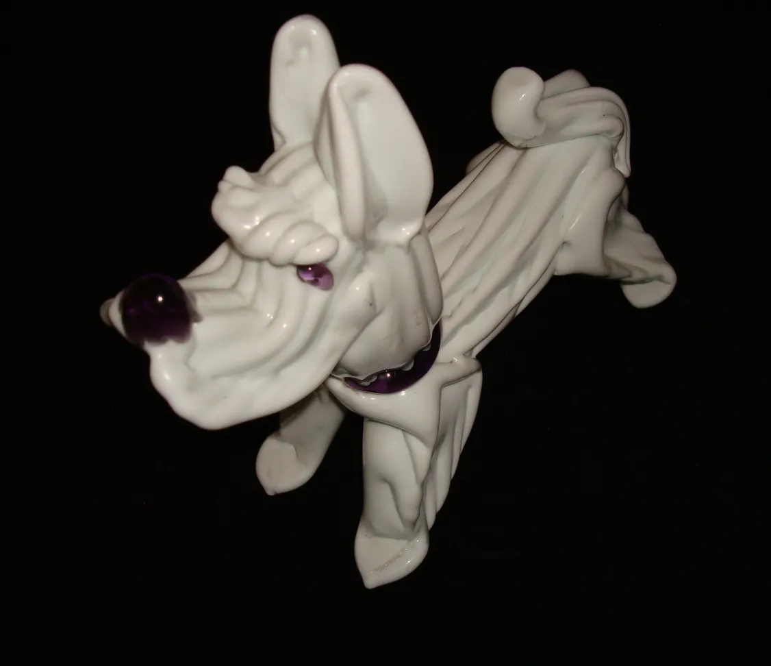 escultura antigua de un perro blanco con detalles morados