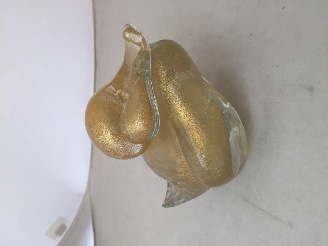 escultura de murano antigua con detalles brillantes y formas fluidas, color dorado, ambiente elegante