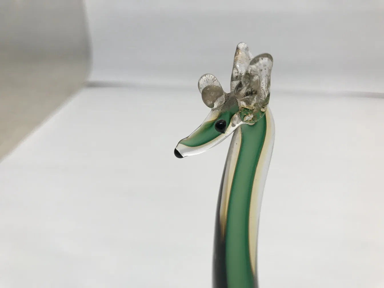 escultura murano antiga com cores vibrantes e detalhes únicos, contra um fundo neutro