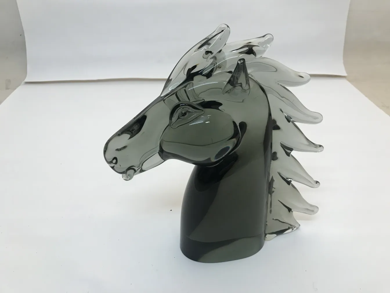 Escultura de Murano em forma de cabeça de cavalo com detalhes suaves e elegantes, representando a antiguidade.