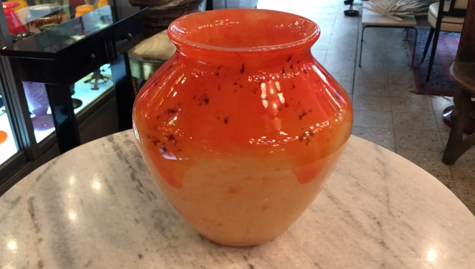 Vaso antico in vetro firmato, di colore arancione brillante con un design unico.