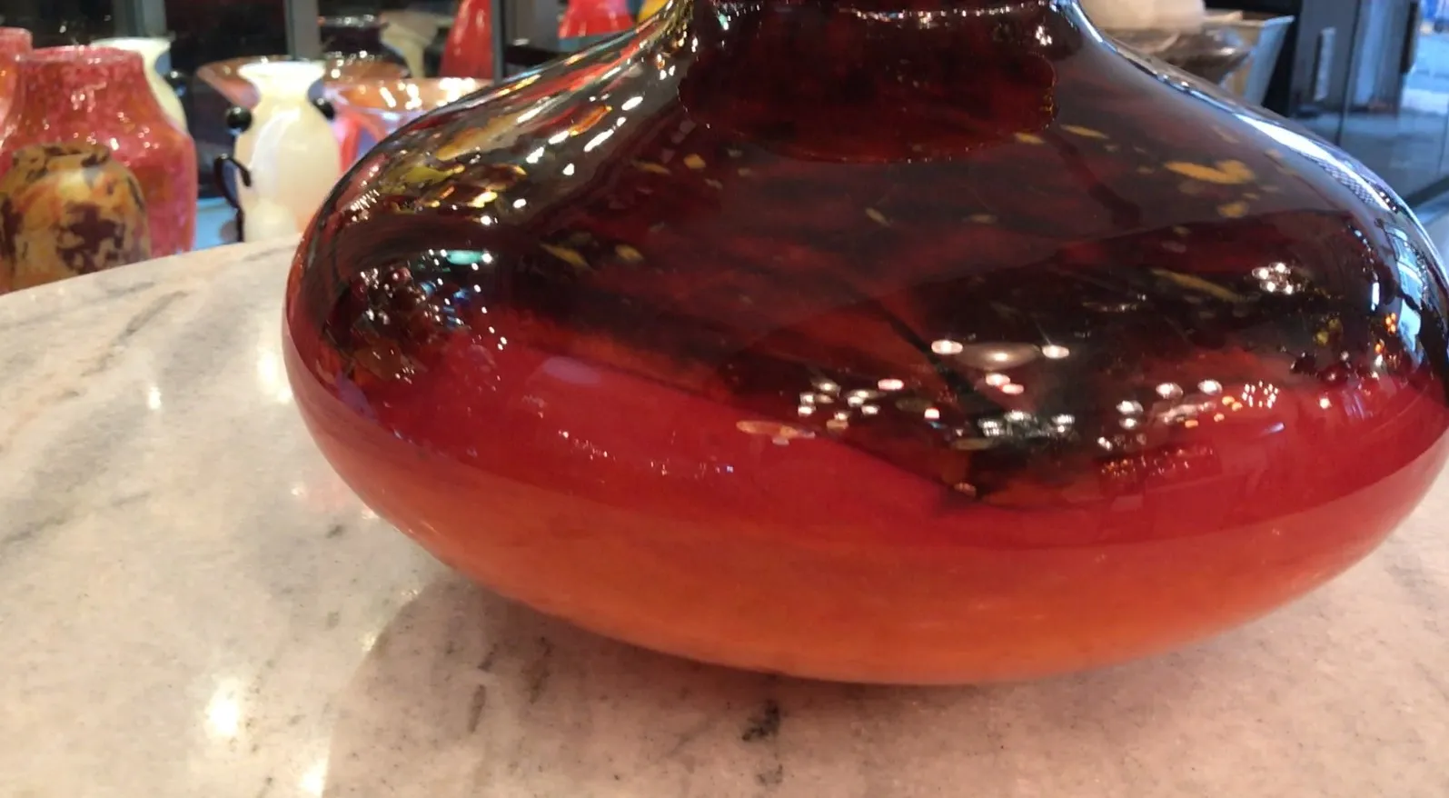 signiertes Glas Schneider in warmen Tönen mit reflektierten Lichtern