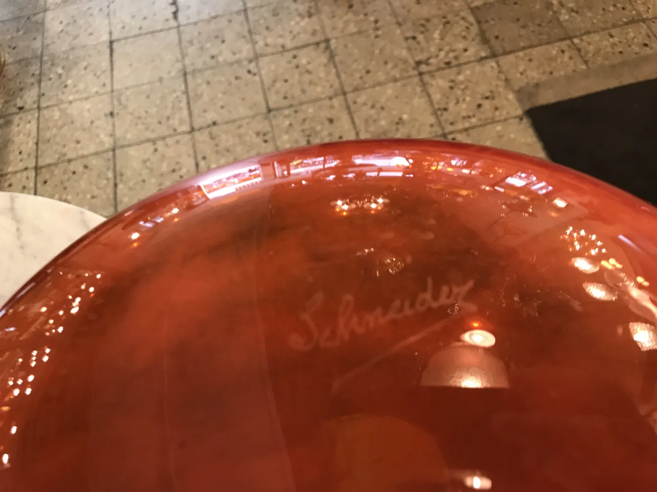 Vidro assinado Schneider em um ambiente antigo com detalhes artísticos