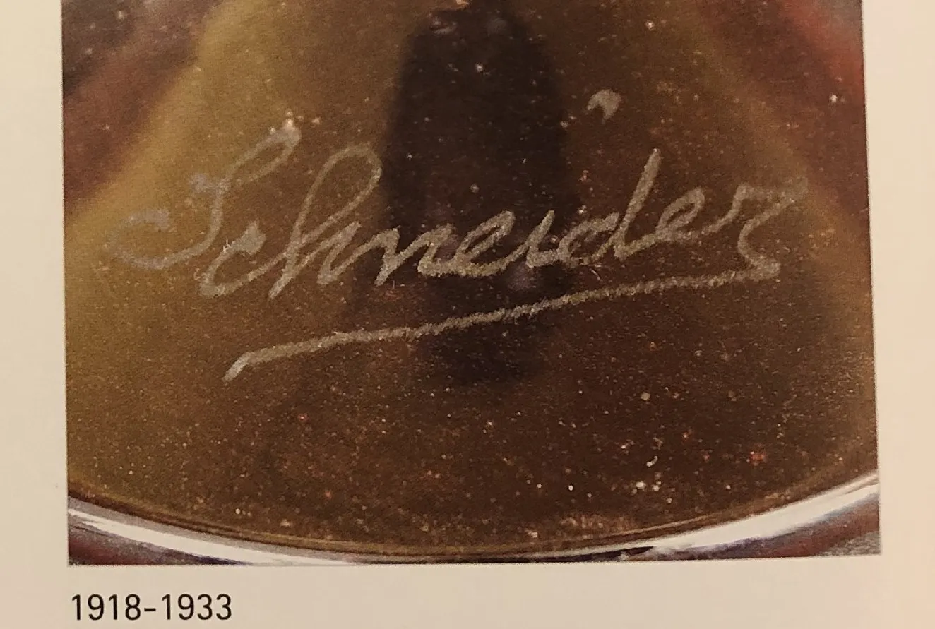 Detalles de un antiguo vidrio firmado por Schneider con una firma clara.