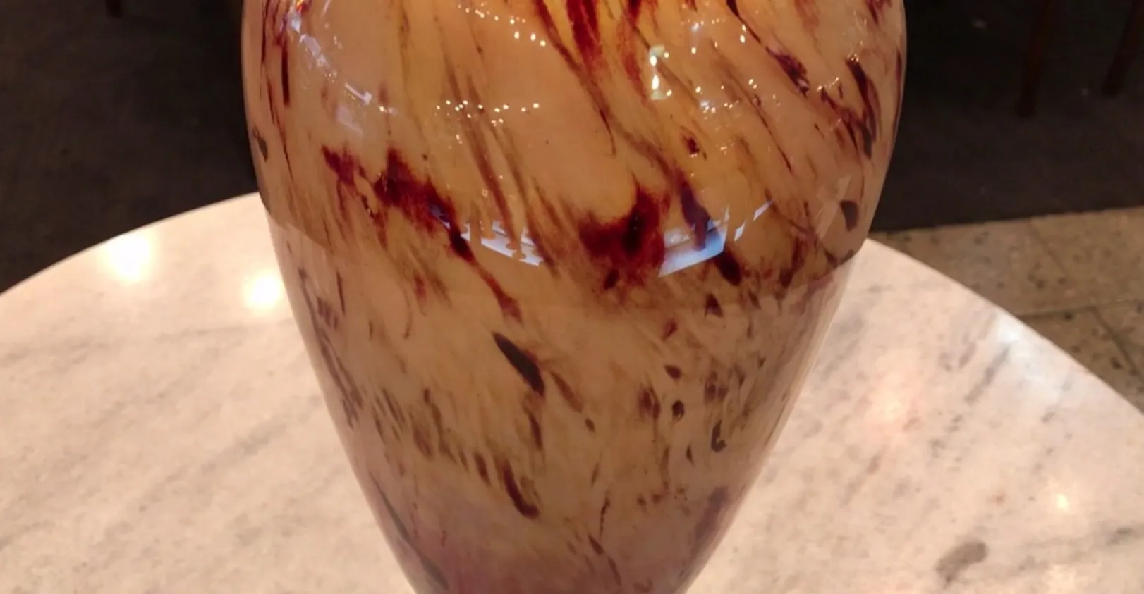 Vaso in vetro antico firmato da Schneider con un design colorato. Presenta un ambiente elegante.