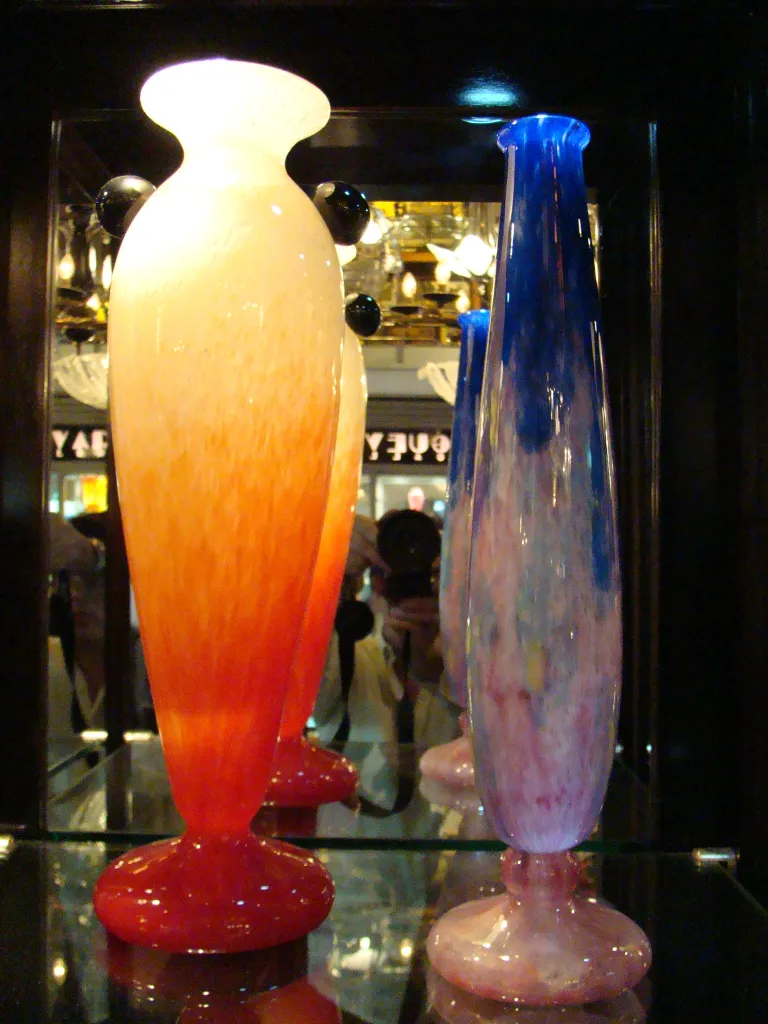 deux vases en verre ancien, un rouge et un bleu, sur fond sombre